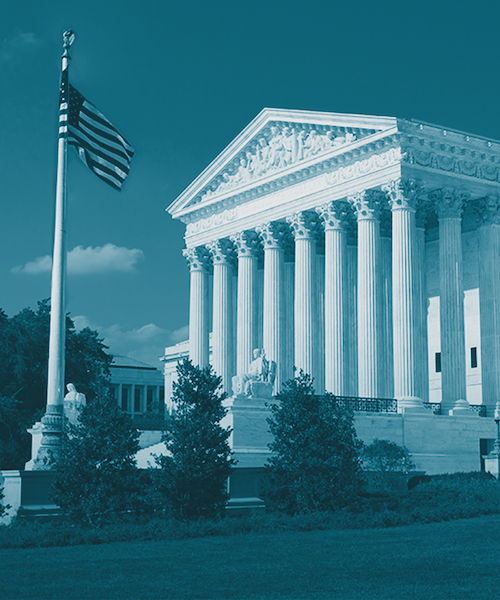 Monochrome image of the United States Supreme Court building with a cyan tone filter, featuring the American flag on the left.